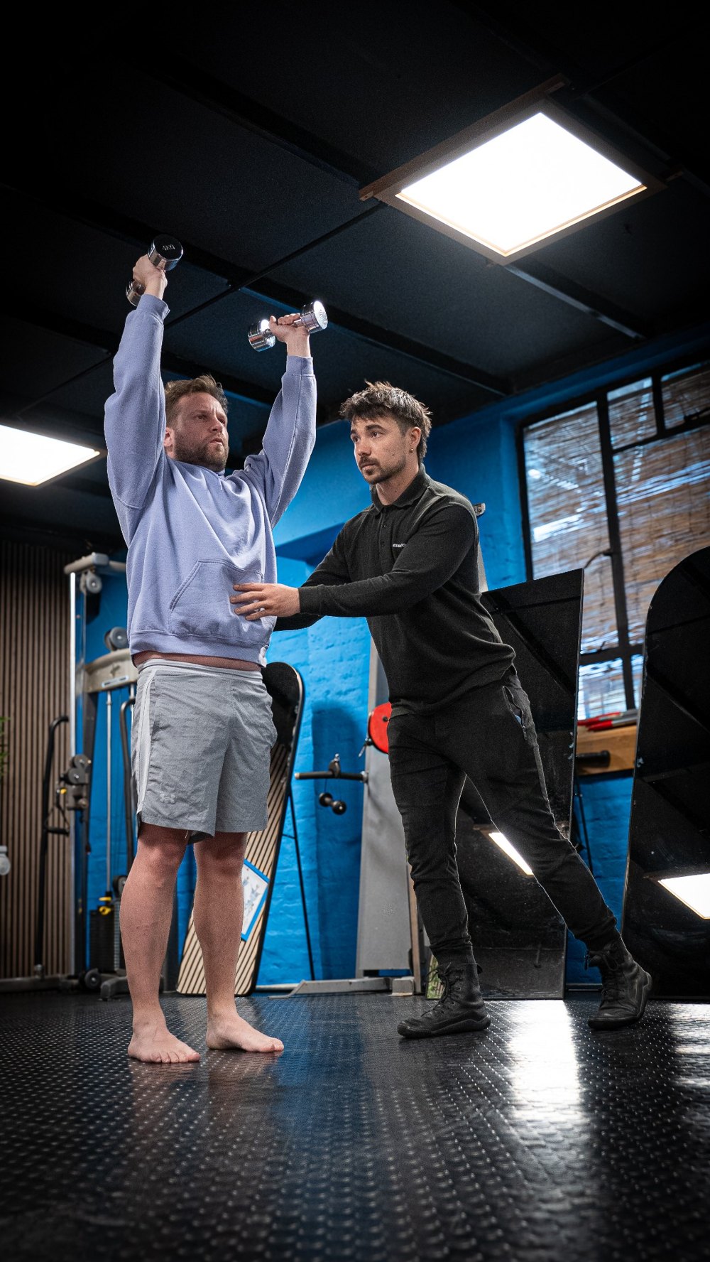A coach providing hands-on guidance during standing movement practice